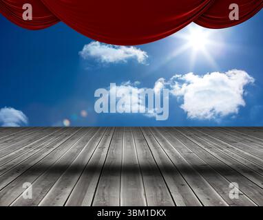 Die flache Abbildung zeigt den Bühnenboden aus Holzdielen mit roten Samtvorhängen, Sonne und Wolken Stockfoto