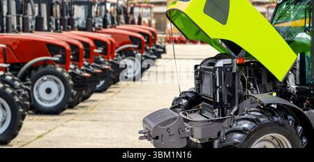 Traktor mit offener Motorhaube am Los des Händlerbetriebs für landwirtschaftliche Geräte Stockfoto