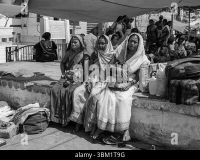 Indien, Vrindavan, 16. März 2025. Frauen in farbenfrohen Saris ruhen sich während einer Pilgerfahrt unter einem Baldachin neben den Yamuna Ghats in Vrindavan, Uttar Pradesh, aus Stockfoto