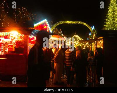 Zauberhafte Weihnachtsmarktbeleuchtung in Frankreich mit Silhouetten und festlicher Menge Stockfoto