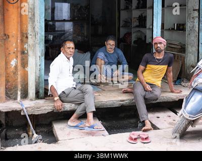 Indien, Jaipur, 14. März 2025. Drei indische Männer, die sich während eines Holi Festivals in der Altstadt entspannen und sich unterhalten, eine offene Straßenszene. Stockfoto