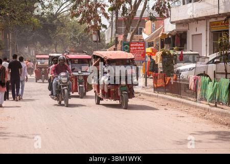 Indien, Jaipur, 14. März 2025. Blaue elektrische Rikscha (E-Rikscha), die Passagiere während des Holi Festivals, dem traditionellen indischen Markt in, auf belebten Straßen befördert Stockfoto