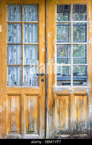 Gelbe Holztür mit Fenstern auf einem Cottage Stockfoto