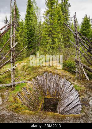 Elch- oder Elchfalle, die im Winter mit Stöcken und Schnee bedeckt wäre, mit einem Leitzaun in einem Wald in der Region Valdres in Zentralnorwegen Stockfoto