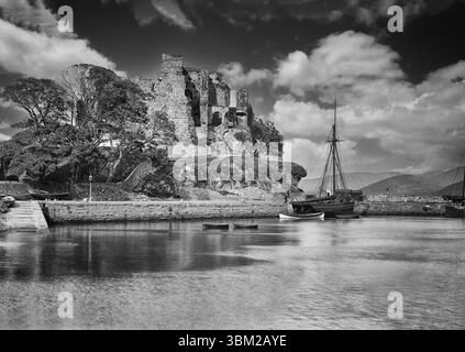 Ein Foto aus dem späten 19. Jahrhundert eines hölzernen Segelschiffes, das an den Kais unterhalb der Ruine von King John's Castle in Carlingford, County Louth, Irland, ankerte. Erbaut im späten 12. Jahrhundert von Hugh de Lacy, Lord of Meath, kurz nach der normannischen Invasion Irlands. Sie erhielt ihren Namen, nachdem König John 1210 während seiner zweiten Expedition drei Tage dort verweilte, als er in Ulster einmarschierte, um Said Hugh de Lacy festzunehmen. Später, nach der Schlacht am Boyne, feuerten die Jakobiten 1689 auf die Burg, als Wilhelm von Orange seine verwundeten Soldaten dort untergebracht haben soll. Stockfoto