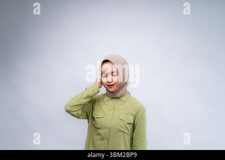 Verwirrtes und stressiges Gesicht junger asiatischer Frauen, die Hijab mit Handgesten tragen. Konzept des Werbemodells. Stockfoto