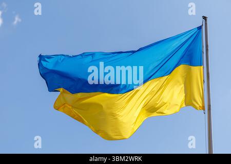 München, Deutschland. Juni 2025. Die Flagge der Ukraine fliegt am 24. Juni 2025 auf einem Fahnenmast gegen den blauen Himmel in München (Bayern) im Wind. Quelle: Matthias Balk/dpa/Alamy Live News Stockfoto