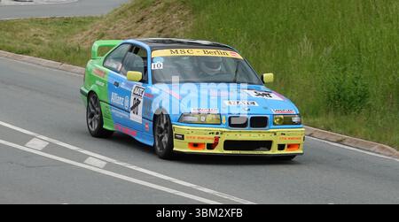 Farbenfrohe BMW Tourenwagen-Rennen in der ADMV Classic Serie in Deutschland. Klassische Motorsportszene mit modifiziertem BMW auf einem geschlossenen Rundkurs. Stockfoto