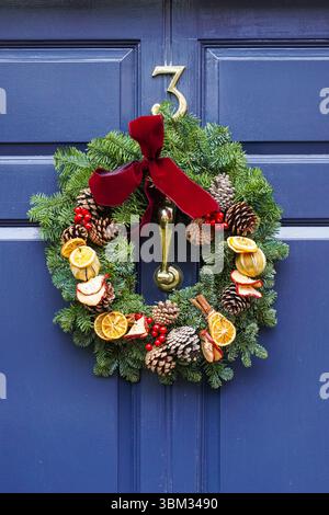 Ein dekorativer Weihnachtskranz hängt an der Haustür eines Hauses in Kensington, London, England, Großbritannien Stockfoto