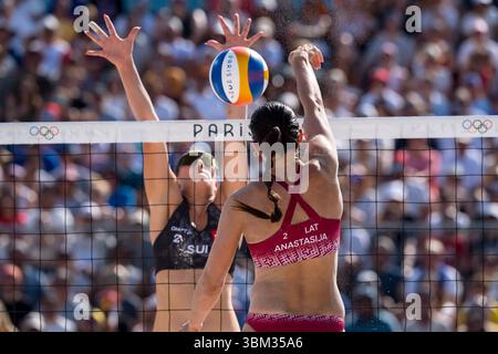 Die lettische Blocker TINA GRAUDINA (LAT) (1) und die lettische Verteidigerin ANASTASIJA SAMOILOVA (LAT) (2) treten während ihrer Vorphase - Pool D Frauen-Beachvolleyball-Match im Stadion Stade Tour Eiffel bei den Olympischen Sommerspielen 2024 in Paris, Frankreich, gegen die Schweiz an. Schweiz Stockfoto
