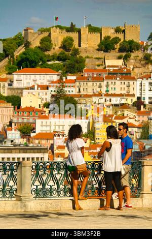Touristen genießen einen Panoramablick auf Castelo de São Jorge vom Aussichtspunkt São Pedro de Alcântara, Lissabon, Portugal Stockfoto