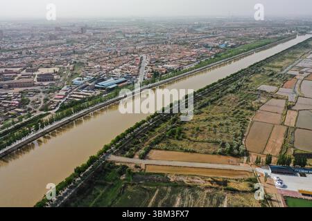 (250624) -- BAYANNUR, 24. Juni 2025 (Xinhua) -- ein Luftdrohnenfoto vom 28. Mai 2025 zeigt den Hauptkanal in der Grafschaft Dengkou in Bayannur, Nordchinas autonomer Region Innere Mongolei. Bayannur liegt an der Spitze der „Großen Schlaufe“ des Gelben Flusses und im Herzen der Hetao-Ebene. Bayannur ist eine Stadt, die vom Gelben Fluss gepflegt wird und als Speicher im Norden Chinas bekannt ist. Das Wort Bayannur bedeutet auf Mongolisch „üppiger See“ und beschreibt perfekt die Wasserressourcen der Region. Von oben betrachtet, zeigt das Hetao Bewässerungsgebiet ein ausgedehntes 64.000-km-Netz von Bewässerungskanälen, das Stockfoto