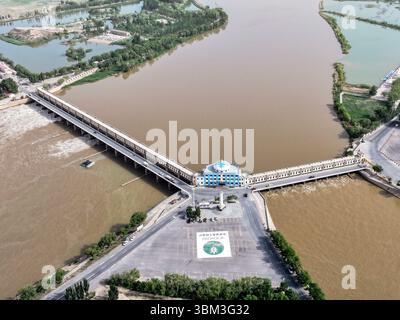 (250624) -- BAYANNUR, 24. Juni 2025 (Xinhua) -- ein Luftdrohnenfoto vom 28. Mai 2025 zeigt das Wasserkontrollprojekt Sanshenggong im Dengkou County in Bayannur, Nordchinas Autonomer Region Innere Mongolei. Bayannur liegt an der Spitze der „Großen Schlaufe“ des Gelben Flusses und im Herzen der Hetao-Ebene. Bayannur ist eine Stadt, die vom Gelben Fluss gepflegt wird und als Speicher im Norden Chinas bekannt ist. Das Wort Bayannur bedeutet auf Mongolisch „üppiger See“ und beschreibt perfekt die Wasserressourcen der Region. Von oben betrachtet, zeigt das Hetao Bewässerungsgebiet ein ausgedehntes 64.000-km-Netz von i Stockfoto