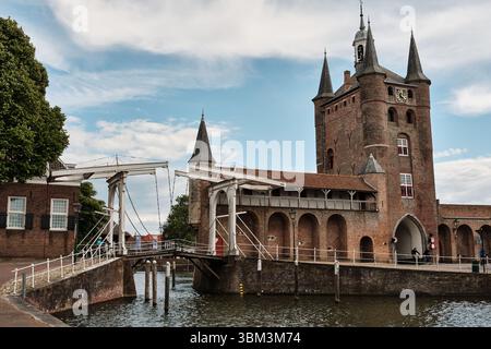 26. Mai 2025 - Zierikzee-Niederlande: Weiße hölzerne Zugbrücke und mittelalterliches Stadttor aus Stein Zuidhavenpoort am historischen Hafeneingang von Zierikzee Stockfoto
