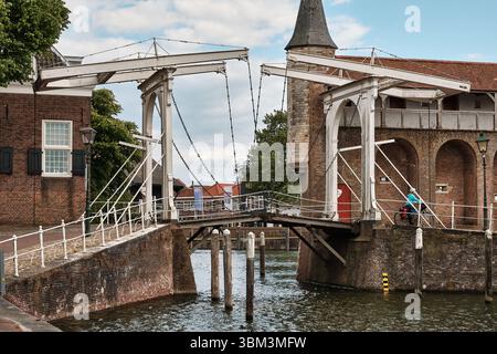 26. Mai 2025 - Zierikzee-Niederlande: Weiße hölzerne Zugbrücke und mittelalterliches Stadttor aus Stein Zuidhavenpoort am historischen Hafeneingang von Zierikzee Stockfoto