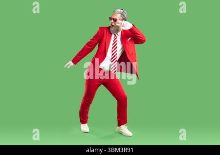 Positiver extravaganter, grauhaariger Weihnachtsmann in klassischem, stilvollem rotem Anzug. Stockfoto