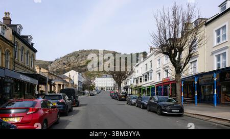 Llandudno, Wales, Großbritannien - 20. März 2025; Blick auf die Stadt entlang der Mostyn Street in Llandudno mit geparkten Autos Stockfoto