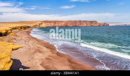 Ein atemberaubender Blick auf Playa Roja, bekannt für seinen einzigartigen roten Sand und die dramatischen Klippen im Paracas Natural Reserve. Stockfoto