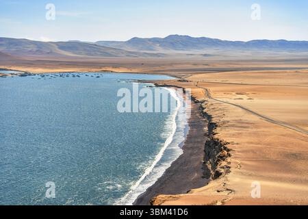 Ein atemberaubender Blick auf Playa Roja, bekannt für seinen einzigartigen roten Sand und die dramatischen Klippen im Paracas Natural Reserve. Stockfoto