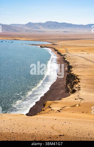 Ein atemberaubender Blick auf Playa Roja, bekannt für seinen einzigartigen roten Sand und die dramatischen Klippen im Paracas Natural Reserve. Stockfoto