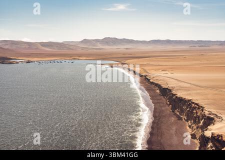 Ein atemberaubender Blick auf Playa Roja, bekannt für seinen einzigartigen roten Sand und die dramatischen Klippen im Paracas Natural Reserve. Stockfoto