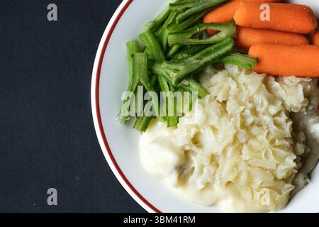 London UK, 24. Juni 2025, traditioneller leckerer gebackener Fischkuchen mit Karotten und Runnner Bohnen Stockfoto