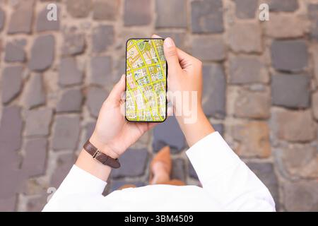 Frau, die draußen auf ihrem Handy einen Stadtplan ansieht, Nahaufnahme Stockfoto