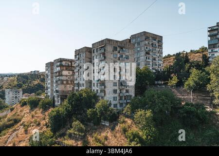 Fotos von alten Wohngebäuden aus Betonplatten aus den 1970er Jahren in Tiflis, Georgien. Diese ikonischen Beispiele brutalistischer Architektur aus der Sowjetzeit spiegeln den krassen, utilitaristischen Stil jener Zeit wider. Rohtexturen, sich wiederholende Geometrien und verwitterte Fassaden sprechen vom historischen und sozialen Kontext der Stadtentwicklung während der Sowjetzeit. Stockfoto