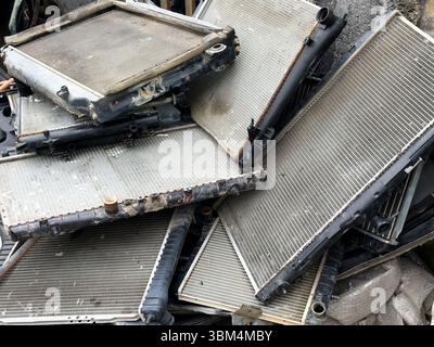 Alte gebrauchte Kfz-Heizkörper in Schrott gestapelt, Recycling von Automobilabfällen, Entsorgung von Fahrzeugteilen, Metallrückgewinnung, beschädigte Kühlsysteme, Industrie-Müll und Ersatzteile. Stockfoto