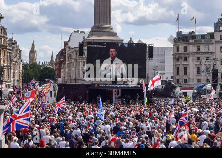 London, Großbritannien. Juli 2024. Das Filmmaterial von Stephen Christopher Yaxley-Lennon, auch bekannt als Tommy Robinson, wird auf einem Bildschirm am Trafalgar Square gezeigt, während sich Menschenmassen zu einem rechtsgerichteten Protest gegen die Einwanderung versammeln. Quelle: Vuk Valcic/Alamy Live News Stockfoto