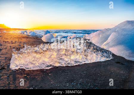 Beeindruckende Teile des Eisbergs funkeln am berühmten Diamond Beach in der Lagune von Jokulsarlon während des Sonnenuntergangs. Lage : Jokulsarlon Lagune, Diamond Beach, V Stockfoto
