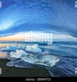 Beeindruckende Teile des Eisbergs funkeln am berühmten Diamond Beach in der Lagune von Jokulsarlon während des Sonnenuntergangs. Lage : Jokulsarlon Lagune, Diamond Beach, V Stockfoto