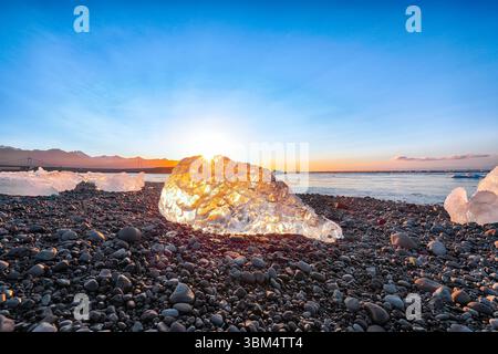 Beeindruckende Teile des Eisbergs funkeln am berühmten Diamond Beach in der Lagune von Jokulsarlon während des Sonnenuntergangs. Lage : Jokulsarlon Lagune, Diamond Beach, V Stockfoto