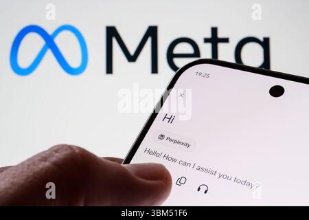 Der Perplexity AI-Assistent begrüßt den Benutzer auf dem Smartphone-Bildschirm vor dem Meta-Logo. Stafford, Großbritannien, 24. Juni 2025 Stockfoto