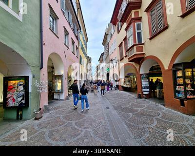 Stimmungsvoller Spaziergang entlang der mittelalterlichen Fußgängerzone Via-dei-Portici mit farbenfrohen Häuserfassaden im Kurort Meran in Südtirol Stockfoto