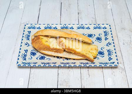 Perfekte Kombination aus Brot, außen knusprig und innen weich, umhüllt eine großzügige Portion Kartoffeltortilla Stockfoto