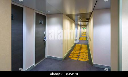 Tokio, Japan - 2. Oktober 2024, Panoramablick auf den langen Korridor zwischen den Türen der Wohnkabinen auf einem der Decks des Kreuzfahrtschiffs MSC Bellissima, W Stockfoto