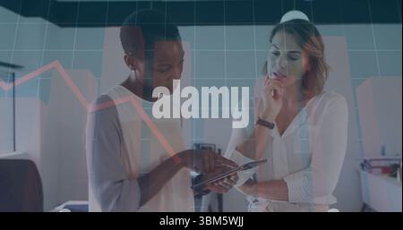 Überprüfung von zwei professionellen Frauen, die Daten auf einem Tablet im Großraumbüro analysieren, mit Diagrammüberlagerungen. Unternehmen, Teamwork, modern, Analytics, Business, Stockfoto