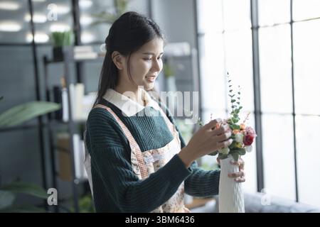 Glückliche asiatische Floristin Startup Kleinunternehmen erfolgreiches KMU im Blumengeschäft Stockfoto