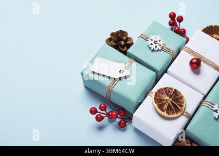 Geschenkboxen in Papier verpackt, mit Kugeln und Garn verziert. Öko-weihnachtliche Einrichtung Stockfoto