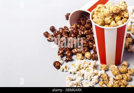 Popcorn-Set in weiß-roter Tasse mit Papierstreifen. Süßes und salziges Popcorn Stockfoto
