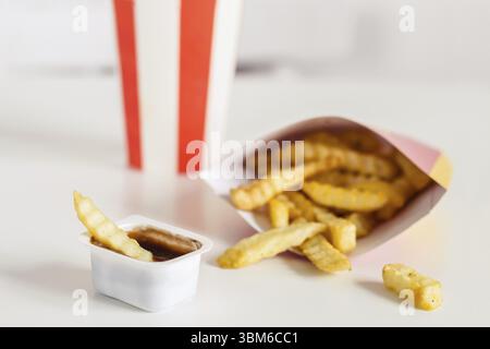 Pommes Frites und Cola auf weißem Hintergrund, selektiver Fokus Stockfoto