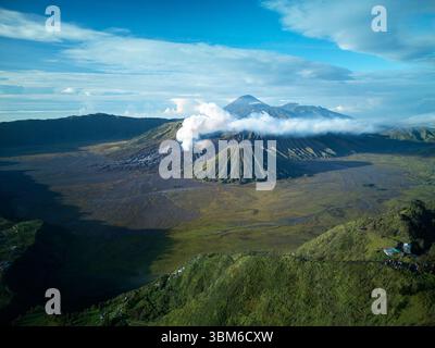 Rauch und Dampf kommen vom Berg Bromo (Gunung Bromo) mit dem Berg Semeru in der Ferne, Ost-Java, Indonesien - aus der Luft Stockfoto