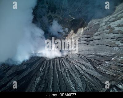 Blick in den rumpelnden Krater des Vulkans Bromo (Gunung Bromo) Ost-Java, Indonesien - aus der Luft Stockfoto