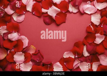 Liebe romantische Hintergrund. heart frame von Rosenblättern auf rotem Hintergrund Stockfoto
