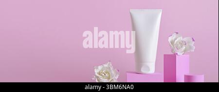 Banner mit Beauty Naturhautpflegeprodukt. Creme-Tube und Blüten auf verschiedenen geometrischen Podien. Präsentation von Körperpflegeprodukten Stockfoto