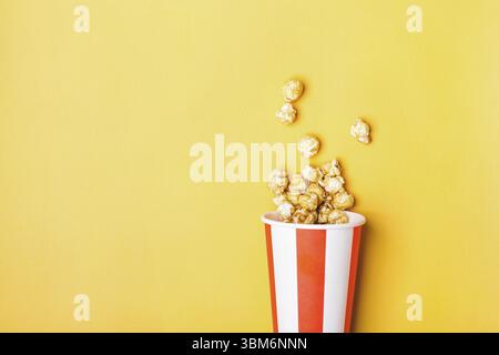 Süßes Karamell-Popcorn in papiergestreifter weißer roter Tasse Stockfoto