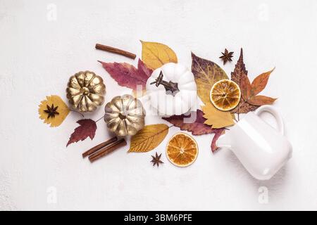 Kreatives Layout aus goldenen Kürbissen und Blättern. Herbstliche Blumenkomposition Stockfoto