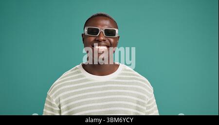 Glücklich, Sonnenbrille und Gesicht eines schwarzen Mannes im Studio mit trendigem Stil, Kleidung und Outfit. Haltung, Mode und Porträt der Person mit Accessoires und Stockfoto