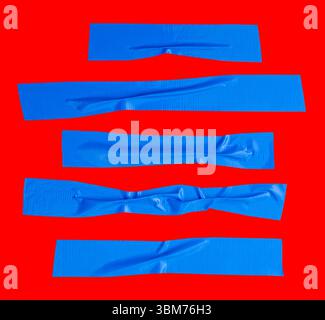 Draufsicht Set aus zerknittertem oder zerknittertem blauem Vinylklebeband oder Stoffband in Streifenform ist auf rotem Hintergrund mit Beschneidungspfad isoliert. Stockfoto
